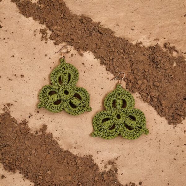 Pendientes tejidos Susi en verde caza sobre fondo terroso mostrando detalle de crochet.