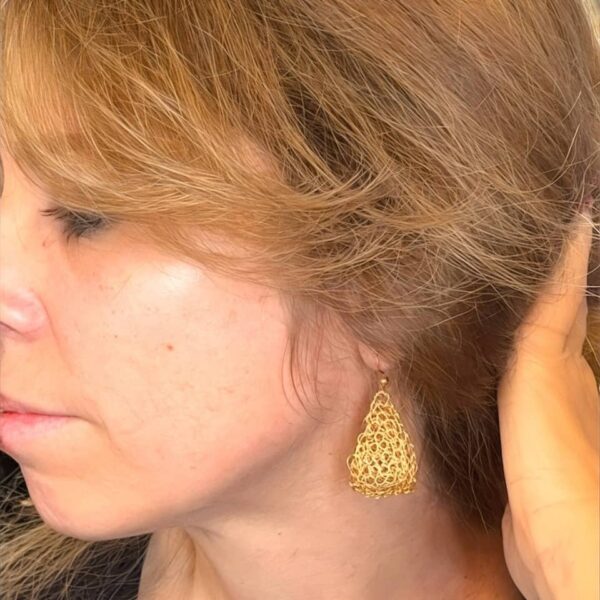 Aretes Noe tejidos en alambre dorado lucidos por Bea creadora de SomosCoquettas.