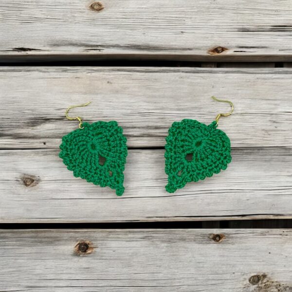 Pendientes Monica a crochet en forma de hojas verde sobre fondo de madera natural.